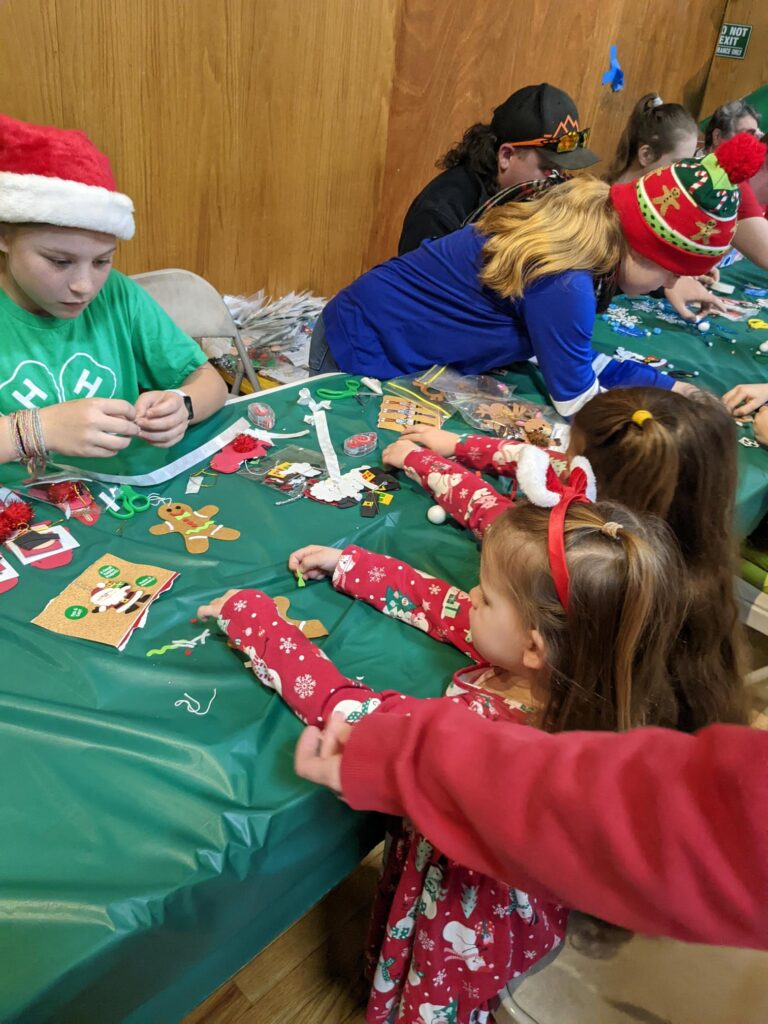 Picture of 4-H Honor Club members making ornaments with young children for a service project.